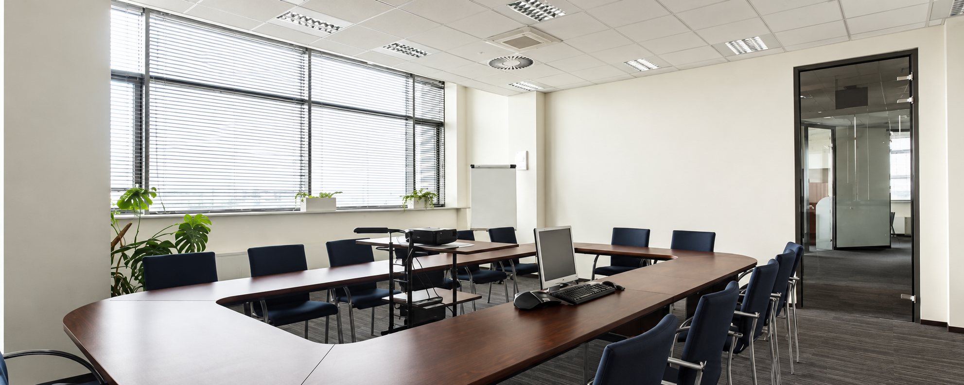 Une salle de réunion lumineuse avec une grande table en U